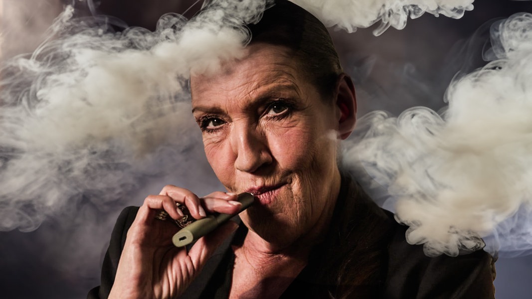 Katy Karrenbauer zieht an einer E-Zigarette, um sie herum viel weißer Rauch.