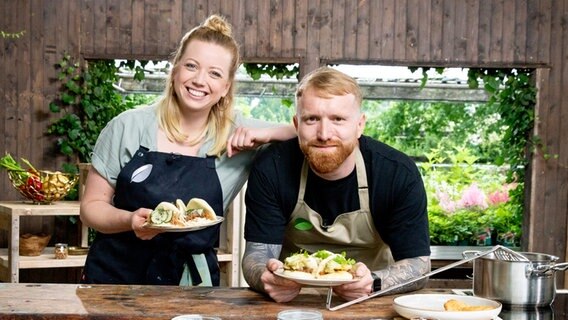 Thilo Haberland und Zora Klipp präsentieren zwei Teller mit Salat und Asia-Burgern. © NDR/cineteam hannover 