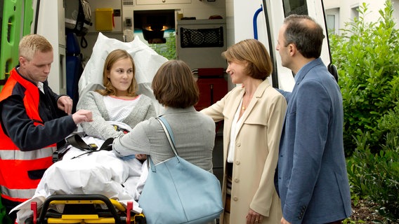 Die 17-jährige Caro (Annika Schrumpf, 2.v.l. mit Komparse, l.) wartet auf eine Spenderniere. Sie wird in die Klinik nach Jena gebracht. Ihre Schwester Julia (Barbara Prakopenka, 3.v.r.), Mutter Claudia (Gisa Zach, 2.v.r.) und Vater Kai Beermann (Robert Schupp, r.) verabschieden sie. Die 17-jährige Caro (Annika Schrumpf, 2.v.l. mit Komparse, l.) wartet auf eine Spenderniere. Sie wird in die Klinik nach Jena gebracht. Ihre Schwester Julia (Barbara Prakopenka, 3.v.r.), Mutter Claudia (Gisa Zach, 2.v.r.) und Vater Kai Beermann (Robert Schupp, r.) verabschieden sie. © NDR/ARD/Volker Roloff