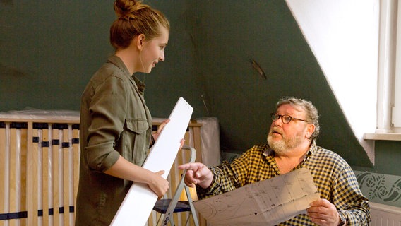 Lotte (Anne Sophie Triesch, l.) erkennt ihr Zimmer nicht wieder, denn Bernd (Walter Plathe, r.) baut gerade Möbel auf. © NDR/ARD/Volker Roloff 