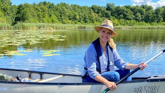 Judith Rakers sitzt in einem Boot auf einem See in Mecklenburg-Vorpommern. © © NDR/WDR/Bavaria/André Conrad 