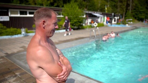 Bademeister David steht mit nacktem Oberkörper am Becken des Freibads in Wildemann. © NDR/Kamera Zwei 