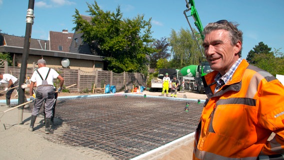 Arwed Berchim auf der Baustelle eines Eigenheims. Für das Fundament und die Sohle des Bauprojektes werden knapp 39 Kubikmeter Beton verbaut. © NDR/Produktion Clipart 
