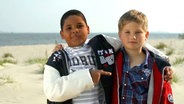 Zwei Jungen stehen am Strand  