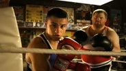 Zwei Boxer stehen im Ring  