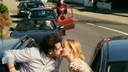 Ein Mann und eine Frau küssen sich auf der Straße  