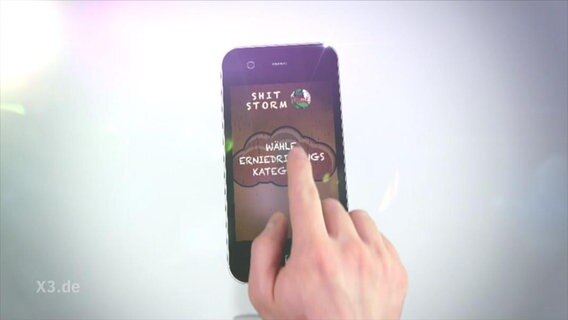 Das Display eines Handys zeigt die Shitstorm-App an.  