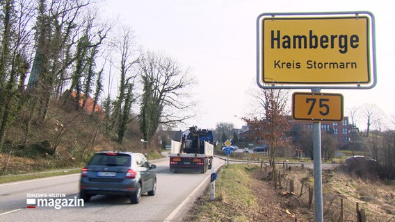 Autos fahren am Ortseingangsschild von Hamberge vorbei © NDR 