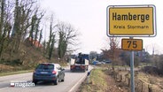 Autos fahren am Ortseingangsschild von Hamberge vorbei © NDR 