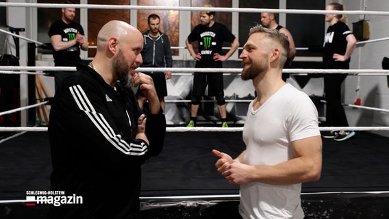 Andre Trucker und NDR-Moderator Philipp Jess stehen vor einer Wrestling Bühne © NDR 