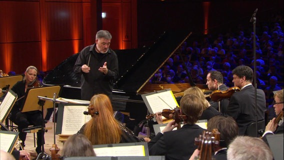 Alan Gilbert und Igor Levit mit dem NDR Elbphilharmonie Orchester beim Eröffnungskonzert des SHMF 2022 in der Lübecker MuK. © Screenshot 