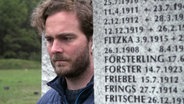 Reporter Tobias Lickes neben einem Grabstein. © NDR/7 Tage 