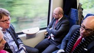 Manuela Schwesig, Ralf Stegner, Martin Schulz und Torsten Albig sitzen mit mürrischen Gesichtern im Zug.  