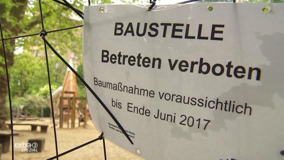 Ein Schild hängt vor einem Spielplatz mit der Aufschrift: "Baustelle - Betreten verboten - Baumaßnahme voraussichtlich bis Ende Juni 2017".  