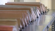 Viele Stasiakten liegen aneinander gereiht auf einem Tisch.  