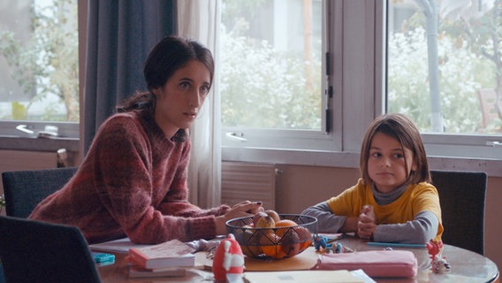 Szenenbild aus der französischen Serie "Ziemlich beste Stiefmutter": Eine Frau und ein Kind sitzen an einem Tisch. © The Film TV 