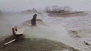 Eine Person steht während der Sturmflut 1976 auf einem Deich. © NDR 