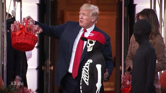 US-Präsident Donald Trump mit einem Kind in einem Halloween-Kostüm.  