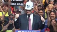 Donald Trump mit einem Helm auf dem Kopf.  