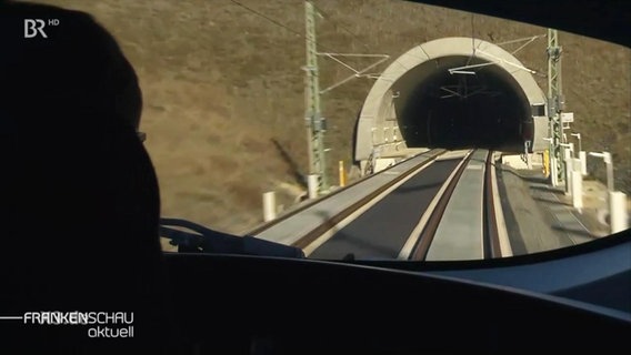 Gleise führen in einen Tunnel.  