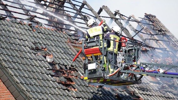 Einsatzkräfte der Feuerwehr löschen einen Dachstuhl eines Wohnhauses. © Screenshot 