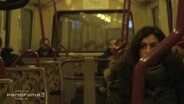 Eine Frau sitzt in einer Hamburger U-Bahn.  