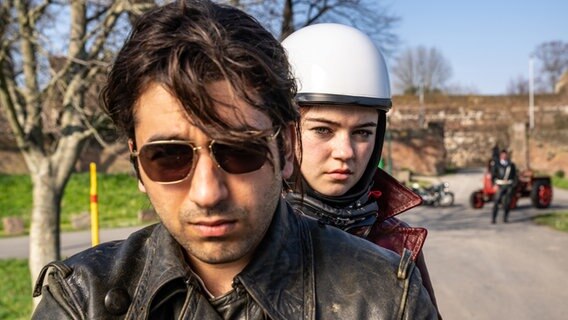 Bijan (Omid Memar) und Betty (Ella Lee) fahren mit dem Motorrad und werden von Schneider (Raphael Westermeier) und seinen Kollegen angehalten und überprüft. © WDR/UFA Fiction/Wolfgang Ennenbach 