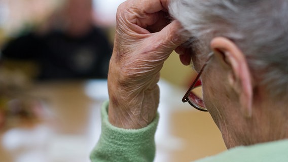 Eine alte Frau stutzt mit der Hand ihren Kopf ab.  © picture alliance Photo: Patrick Pleul