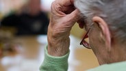 Eine alte Frau stützt mit der Hand ihren Kopf ab. © picture alliance Foto: Patrick Pleul