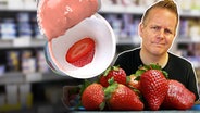 Reporter rechts im Vordergrund mit Erdbeeren, links Joghurtbecher mit einer halben Erdbeere, im Hintergrund unscharf ein Supermarktregal. © Imago 