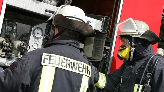 Zwei Feuerwehrleute an einem Einsatzfahrzeug. © colourbox Foto: -