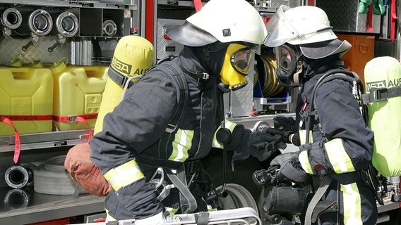 Zwei Feuerwehrleute an einem Einsatzfahrzeug. © colourbox Foto: -