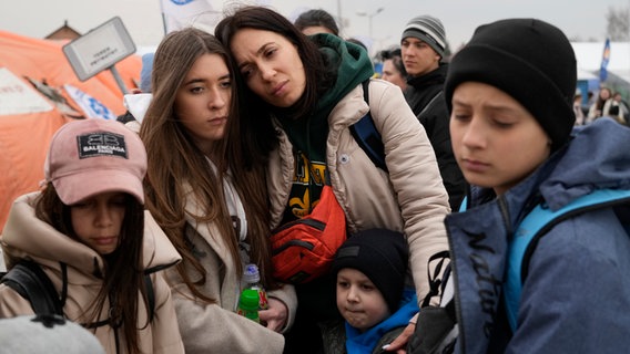 Eine geflüchtete Familie steht müde zusammen © picture alliance/dpa/AP | Sergei Grits Foto: Sergei Grits