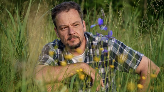 Jan Haft hockt in einer Blumenwiese © Jan Haft 