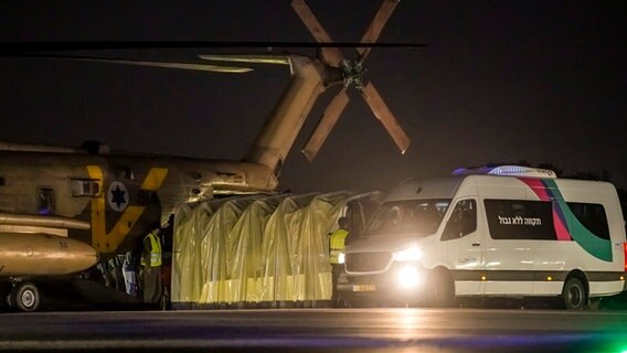 Ein Kleinbus parkt neben einem Hubschrauber mit von der Hamas freigelassenen israelischen Geiseln am Scheba Medical Center in Ramat Gan, Israel. © AP/dpa Foto: Leo Correa