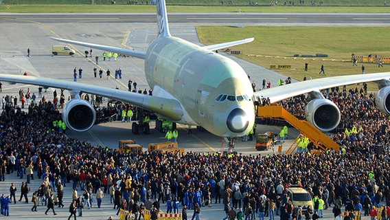 Airbusmitarbeiter umringen ein Flugzeug des Typs A380 auf dem Werksflugplatz in Hamburg-Finkenwerder. © dpa - Report Foto: Kay Nietfeld