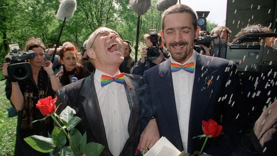 Glücklich "verheiratet" laufen Albert Wehman (l) und Klaus Gasser am 06.05.1999 durch den Reisregen. © picture-alliance / dpa Foto: Stefan Hesse