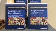 Mehrere Exemplare des Buches "Eingeschlossen - Ausgeschlossen" von Hans-Walter Schmuhl und Ulrike Winkler stehen auf einem Tisch. © NDR Foto: Antonia Reiff