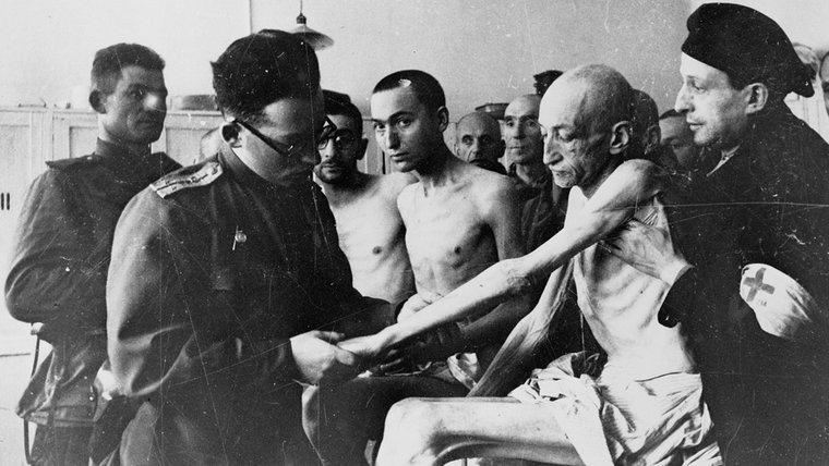 Ein sowjetischer Militärarzt untersucht kurz nach der Auschwitz-Befreiung einen bis auf die Knochen abgemagerten Häftling aus Wien. © dpa - Bildarchiv 