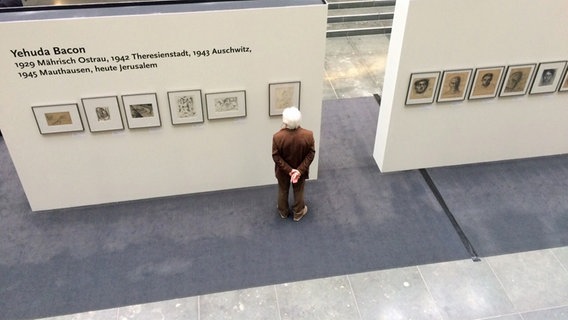 Ein Besucher betrachtet die Werke in der Ausstellung "Der Tod hat nicht das letzte Wort" in Berlin © NDR.de Foto: Carolin Fromm