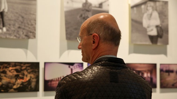 Ein Besucher betrachtet die Bilder der Holocaust-Ausstellung "Niemand zeugt für den Zeugen" in einem Museum in Krakau. © NDR Foto: Judith Pape