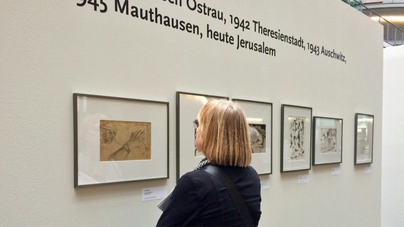 Eine Besucherin betrachtet Bilder von Yehuda Bacon in einer Ausstellung in Berlin © NDR.de Foto: Carolin Fromm