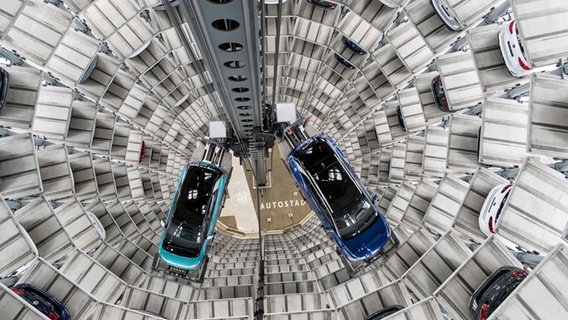 Die Volkswagen-Elektroautos ID.3 (l) und ID.4 stehen 2020 auf einer Transportplattform in einem Autoturm der Autostadt. © picture alliance/dpa Foto: Peter Steffen
