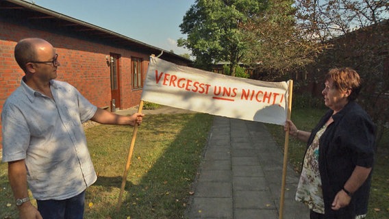 Stephan Dörfel und Hannelore Lüdtke halten ein Transparent der ersten Demo für Menschen mit Behinderungen vom 12.12.1989 in Schwerin. "Aufschrift: Vergesst uns nicht!"  