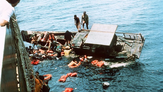 Ein Flüchtlingsboot kentert Ende der 70er-Jahre beim Anlegen an die "Cap Anamur". Alle Flüchtlinge konnten gerettet werden. © dpa - Bildarchiv Foto: Scharsich