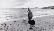 Der französische Chansonnier Georges Brassens (1921 - 1981) 1981 mit Gitarre und Pfeife an einem Strand. © picture alliance / akg-images Foto: Philippe Ledru