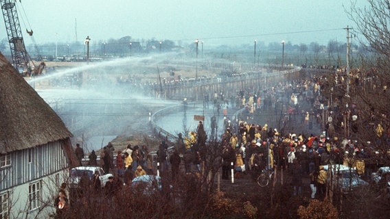 Wasserwerfer der Polizei am 13. November 1976 im Einsatz gegen die Demonstranten vor dem Baugelände des geplanten Kernkraftwerks in Brokdorf. © picture-alliance / dpa Foto: Dieter Klar