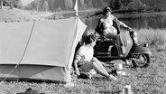 Einen schönen Platz für ihr Zelt haben sich zwei jungen Frauen am Rande eines Sees ausgesucht. (Aufnahme aus den 50er-Jahren) © picture alliance/dpa-Bildarchiv 