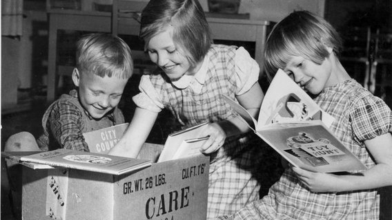 Kinder stöbern in einem Care-Paket. © CARE/www.care.de 