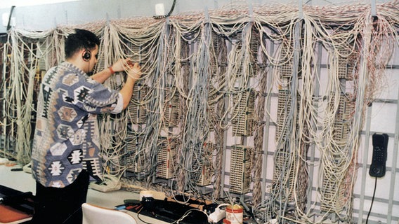Ein Techniker ordnet Kabel an einer Schaltwand im CCH. © Hamburg Messe und Congress-Archiv 